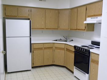 A kitchen with wooden cabinets and a white refrigerator.